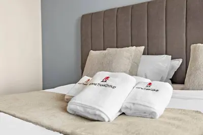 a pile of towels sitting on top of a bed at StoneTree - Modern 1BR with Amazing Building Facilities in Dubai