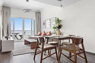 a dining room with a table and chairs at StoneTree - Amazing 1BR with Lake View in Dubai