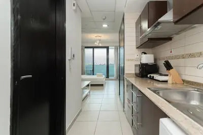 a kitchen with a sink and a view of the ocean at StoneTree - Fully Furnished Studio with Spacious Balcony in Dubai