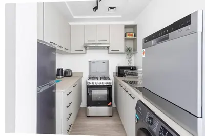 a kitchen with white cabinets and a stove top oven at Exclusive Studio by Burj Khalifa and Dubai Mall, High Floor in Dubai