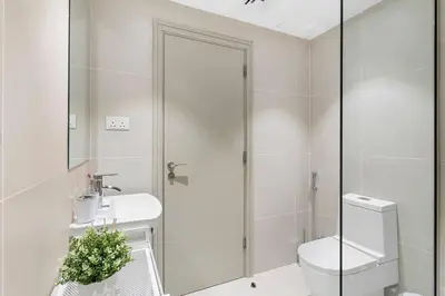a white bathroom with a toilet and a sink at Exclusive Studio by Burj Khalifa and Dubai Mall, High Floor in Dubai