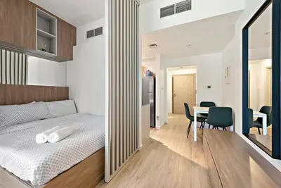 a bedroom with a bed and a table with chairs at Cozy Studio By Burj Khalifa and Dubai Mall in Dubai