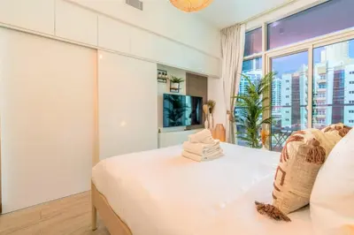 a bedroom with a bed and a large window at Stunning Apt with Balcony & Marina View in Dubai