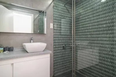 a bathroom with a glass shower with a sink at StoneTree - Spacious 2BR in Great Location in Dubai