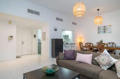 a living room with a couch and a table at StoneTree - Spacious 2BR in Great Location in Dubai