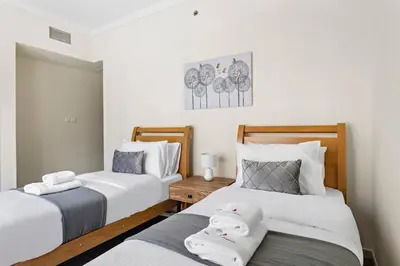 two beds sitting next to each other in a bedroom at Breathtaking Marina View - Spacious Apartment in Dubai