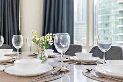 a dining room table with wine glasses and plates at Breathtaking Marina View - Spacious Apartment in Dubai