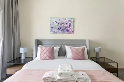 a bedroom with a large bed with pink pillows at Breathtaking Marina View - Spacious Apartment in Dubai