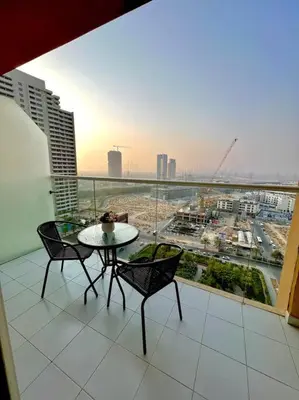 a balcony with a table and chairs and a view of a city at Ghalia Damac Studio Apartment in Dubai