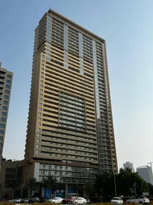 a tall building with cars parked in front of it at Ghalia Damac Studio Apartment in Dubai