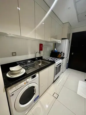 a kitchen with a washing machine and a sink at Ghalia Damac Studio Apartment in Dubai