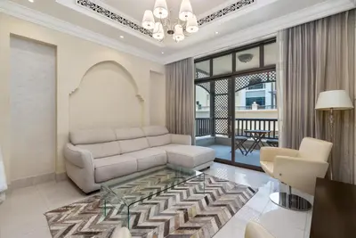 a living room with a couch and a glass coffee table at Lux BnB I Souk Al Bahar I Burj Khalifa Views in Dubai