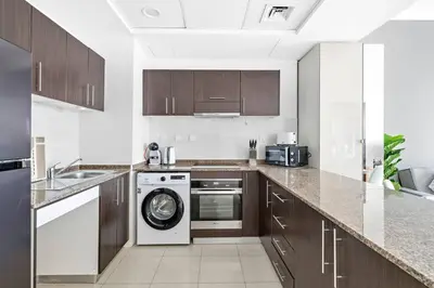 a kitchen with a washing machine and a dishwasher at StoneTree - Elegant 1BR with Amazing Building Facilities in Dubai