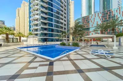 a swimming pool in a city with tall buildings at StoneTree - Elegant 1BR with Amazing Building Facilities in Dubai