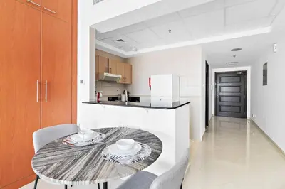 a kitchen with a table and chairs in a room at StoneTree - Best Deal - Elegant Studio in Dubai