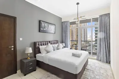 a bedroom with a large bed and a large window at StoneTree - Elegant 1BR in Famous Location in Dubai