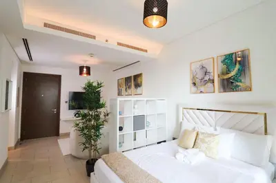 a bedroom with a white bed and a potted plant at Celestial Ambiance Studio in Dubai