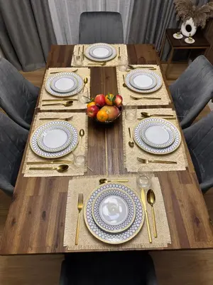 a wooden table with plates and a bowl of fruit on it at Upscale 3br in JBR next to Ritz-Carlton in Dubai