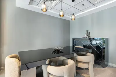a dining room with a black table and chairs at Marina Panorama Paradise in Dubai