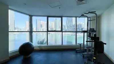 a gym with a view of a city from a large window at Marina Panorama Paradise in Dubai