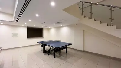 a ping pong table in a room with a staircase at Marina Panorama Paradise in Dubai