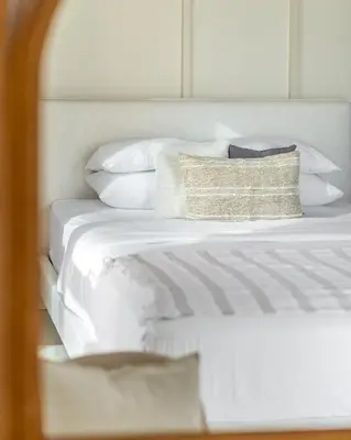 a white bed with white pillows and a pillow on it at GuestReady - Exquisite stay near Dubai Canal in Dubai
