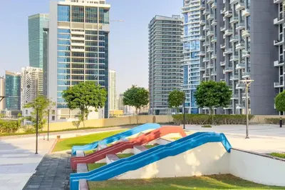 a group of slides in a park with tall buildings at GuestReady - Exquisite stay near Dubai Canal in Dubai