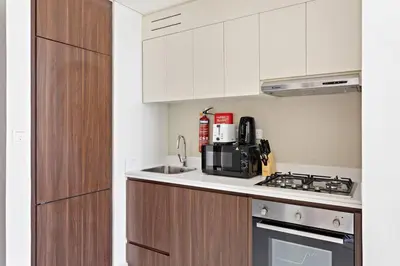 a kitchen with a sink and a stove top oven at StoneTree - Modern 1BR Apartment in Vera Residence in Dubai