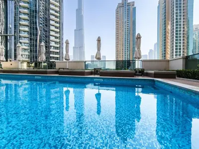 a swimming pool on the roof of a building with tall buildings at Stunning 2 bedroom apartment near Burj Khalifa in Dubai