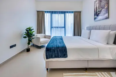 a bedroom with a large bed and a chair at Stunning 2 bedroom apartment near Burj Khalifa in Dubai