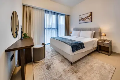 a hotel room with a bed and a desk and window at Stunning 2 bedroom apartment near Burj Khalifa in Dubai