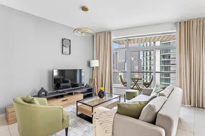 a living room with a couch and a tv at StoneTree - Stylish fully-furnished 1 BR in Dubai