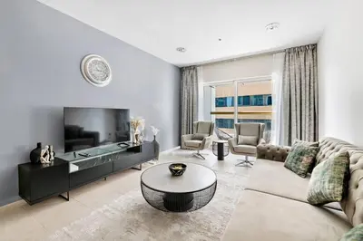 a living room with a couch and a table at StoneTree - High Floor Furnished 1 BR in Dubai