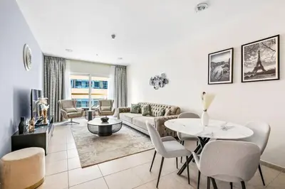 a living room with a couch and a table and chairs at StoneTree - High Floor Furnished 1 BR in Dubai