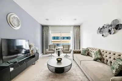 a living room with a couch and a tv at StoneTree - High Floor Furnished 1 BR in Dubai