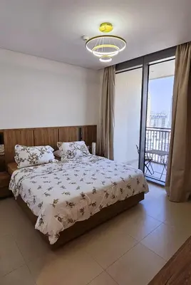 a bedroom with a bed and a large window at Amazing 4-bedroom Apartment in Dubai