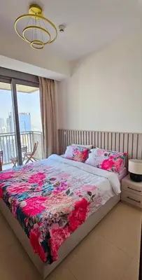 a bedroom with a bed with a floral quilt on it at Amazing 4-bedroom Apartment in Dubai