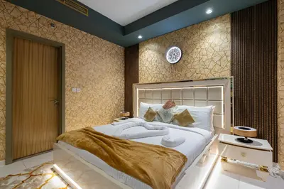 a bedroom with a large white bed with gold accents at Luxury Apartments with Rooftop Pool in Paramount Hotel Midtown By Aurora in Dubai