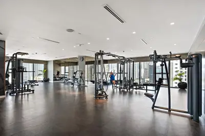 a gym with several tread machines in a large room at Luxury Apartments with Rooftop Pool in Paramount Hotel Midtown By Aurora in Dubai