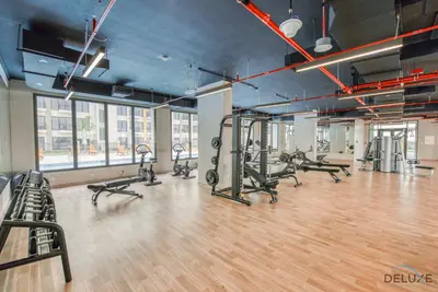 a gym with treadmills and exercise bikes in it at Immaculate 1BR at UNA Town Square Dubailand by Deluxe Holiday Homes in Dubai