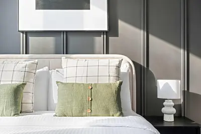 a bedroom with a white bed with green and white pillows at Silkhaus classical 1BDR in Opera District in Dubai