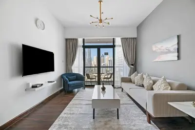 a living room with a couch and a tv at StoneTree - Chic & Modern 1BR in Dubai
