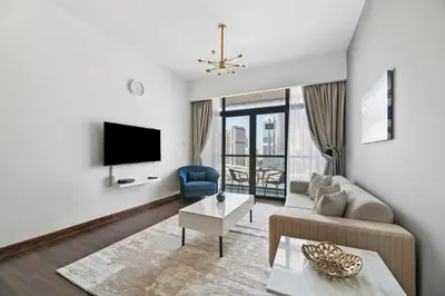 a living room with a couch and a tv at StoneTree - Chic & Modern 1BR in Dubai