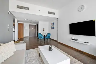 a living room with a large flat screen tv on a wall at StoneTree - Chic & Modern 1BR in Dubai