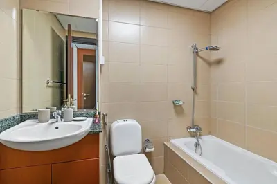 a bathroom with a sink and a toilet and a tub at StoneTree - Chic & Modern 1BR in Dubai