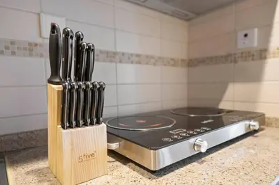 a kitchen counter with knives in a knife block at StoneTree - Modern Furnished Studio in Dubai