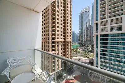 a balcony with chairs and a view of a city at StoneTree - Modern Furnished Studio in Dubai
