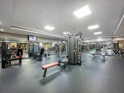 a gym with lots of equipment in a large room at StoneTree - Modern Furnished Studio in Dubai