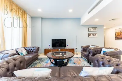 a living room with leather couches and a tv at Spacious Modern 1BR in Business Bay in Dubai