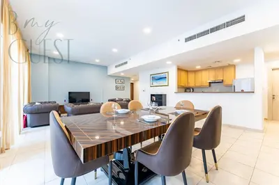 a dining room and living room with a table and chairs at Spacious Modern 1BR in Business Bay in Dubai